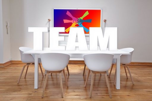 Teamleden van verschillende bureaus overleggen samen aan een vergadertafel