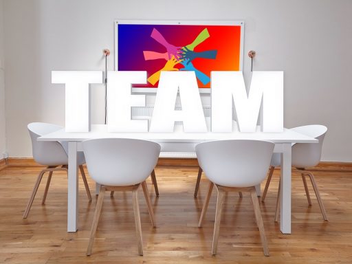 Teamleden van verschillende bureaus overleggen samen aan een vergadertafel