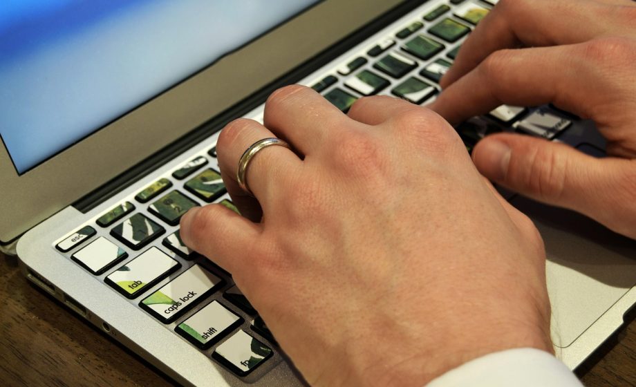 Persoon die zijn dag plant achter een laptop met notities op het scherm