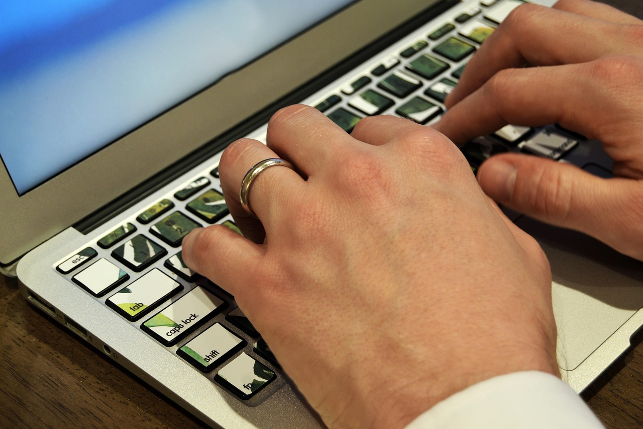 Persoon die zijn dag plant achter een laptop met notities op het scherm