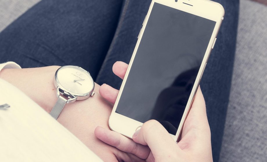 Persoon die via een smartphone augmented reality gebruikt om een meubel virtueel in de woonkamer te plaatsen
