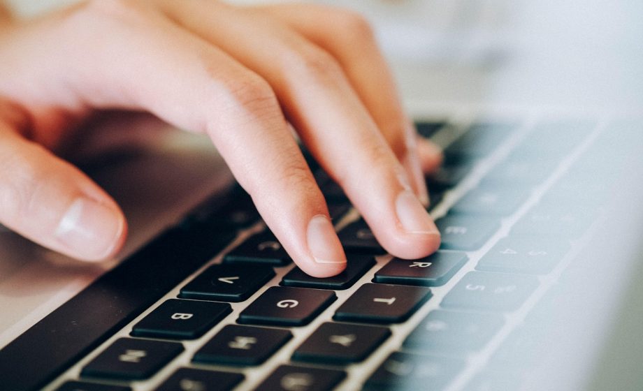 Persoon die op een laptop een moderne website bekijkt