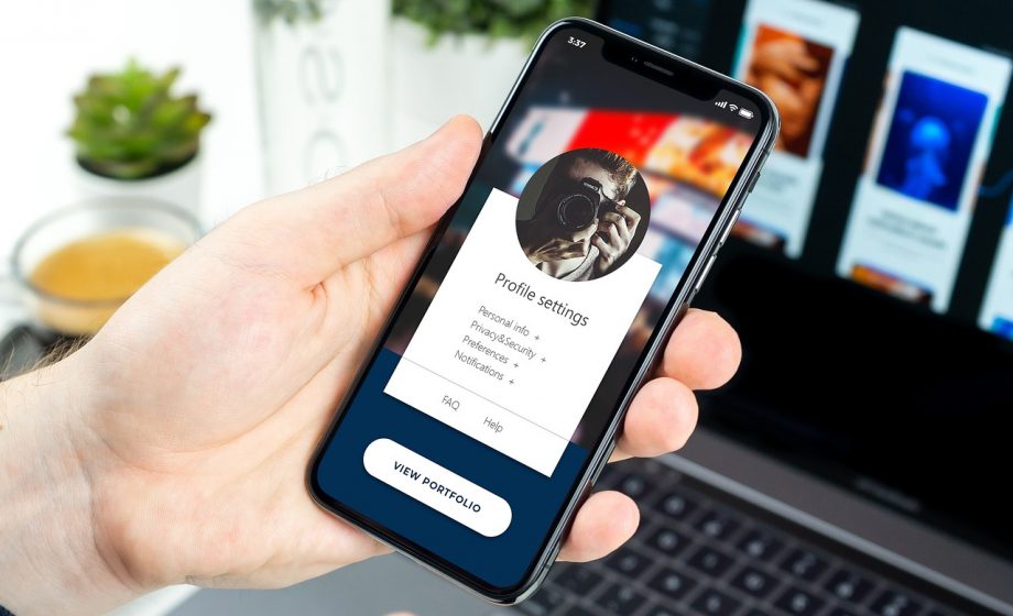 Iemand die door de app-instellingen van een smartphone scrollt om standaard apps te beheren