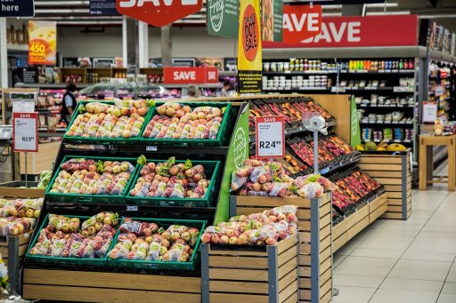 Een digitaal scherm in een winkel dat stof verzamelt naast een kledingrek, symbool voor een mislukte phygital integratie