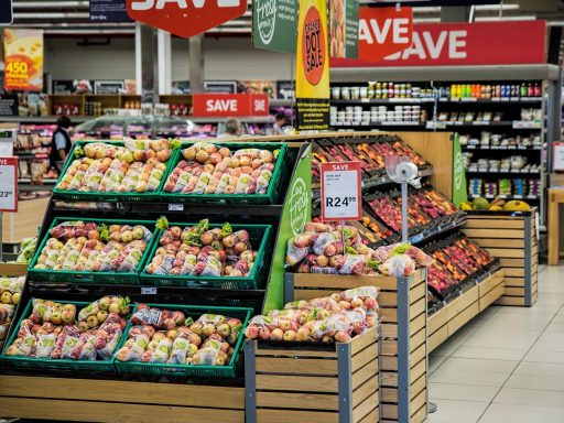 Een digitaal scherm in een winkel dat stof verzamelt naast een kledingrek, symbool voor een mislukte phygital integratie